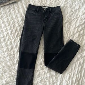 High- Rise Ankle Skinny Jean. All black with detailed knee.